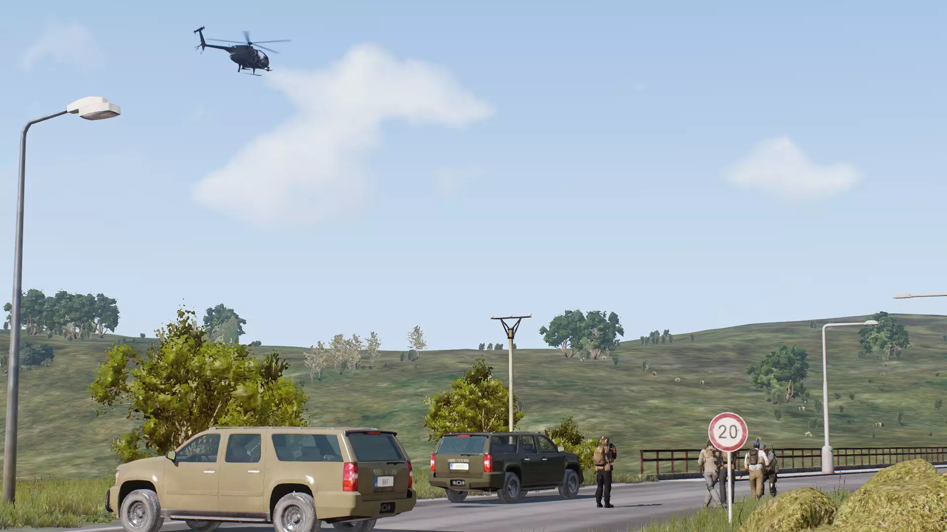 contractors on a bridge with vehicles while a helicopter flies overhead